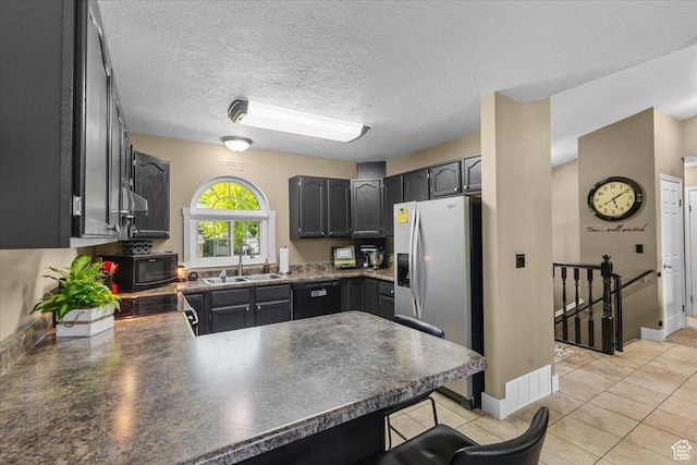980 E 2850 N, North Logan, UT 84341 - kitchen featuring a peninsula, black appliances, dark countertops, a breakfast bar area, and a textured ceiling