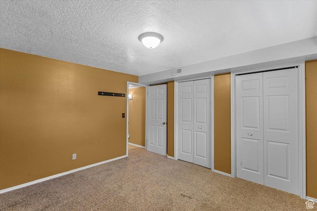 980 E 2850 N, North Logan, UT 84341 - unfurnished bedroom with a textured ceiling, carpet, and multiple closets