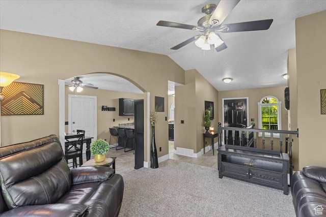 980 E 2850 N, North Logan, UT 84341 - living room with ceiling fan, arched walkways, light colored carpet, lofted ceiling, and light tile patterned flooring