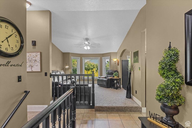 980 E 2850 N, North Logan, UT 84341 - hall featuring an upstairs landing, light colored carpet, a textured ceiling, arched walkways, and light tile patterned floors