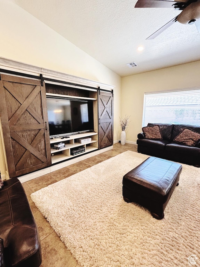 3853 Mitchell Dr, Santa Clara, UT 84765 - carpeted living room with a barn door, a ceiling fan, lofted ceiling, a textured ceiling, and tile patterned floors