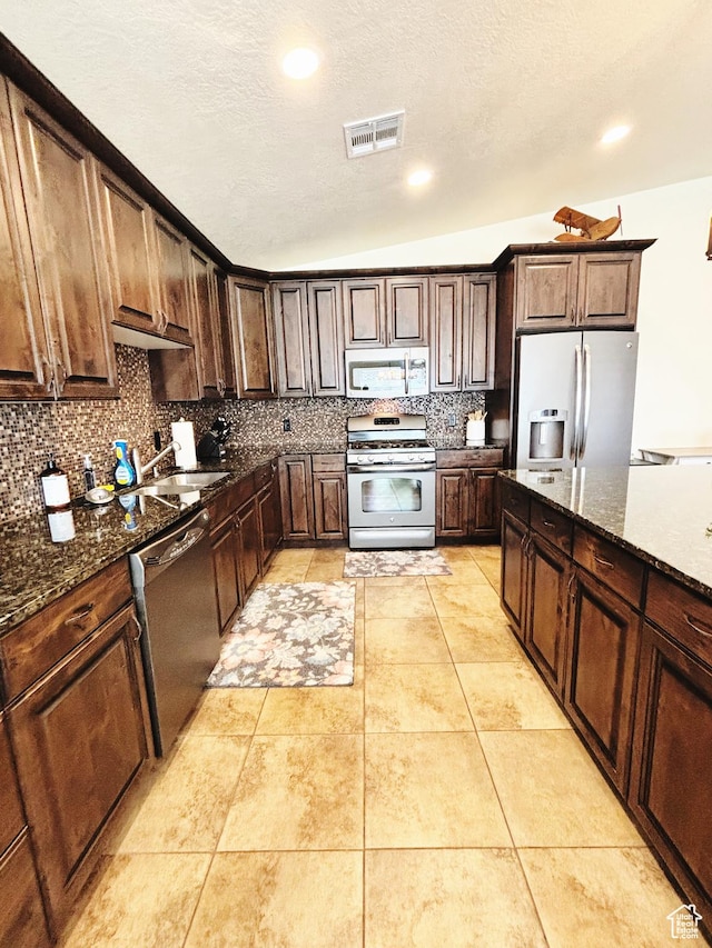 3853 Mitchell Dr, Santa Clara, UT 84765 - kitchen with stainless steel appliances, decorative backsplash, dark stone counters, dark brown cabinets, and recessed lighting