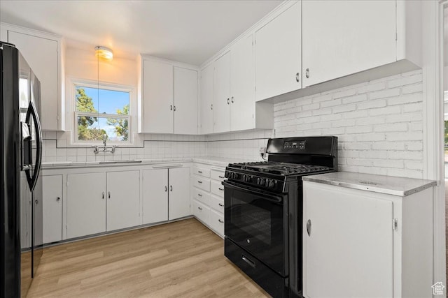374 W Apple St, Grantsville, UT 84029 - kitchen featuring black gas range oven, fridge with ice dispenser, white cabinets, and backsplash