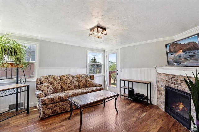 2077 Fillmore Ave, Ogden, UT 84401 - living room with a textured ceiling, a wainscoted wall, plenty of natural light, wood finished floors, and a fireplace