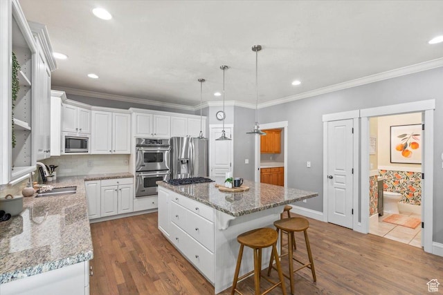 6264 S Dellron Dr, Murray, UT 84123 - kitchen with appliances with stainless steel finishes, a center island, dark wood-type flooring, white cabinets, and crown molding