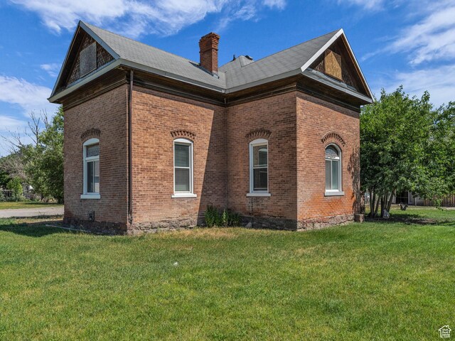 13225 S Redwood Rd, Riverton, UT 84065 - view of property exterior with brick siding, a chimney, and a lawn