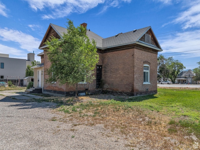13225 S Redwood Rd, Riverton, UT 84065 - view of side of property with brick siding, a chimney, and a yard