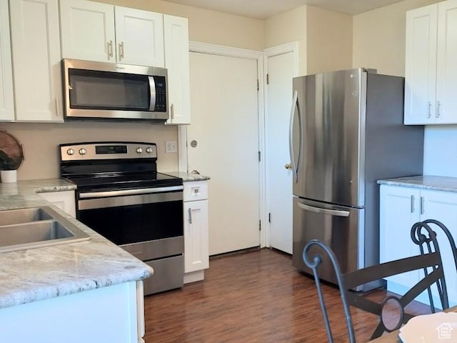 5373 W 6600 S, West Jordan, UT 84081 - kitchen featuring appliances with stainless steel finishes, dark wood-style flooring, white cabinets, and light stone counters