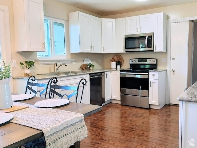 5373 W 6600 S, West Jordan, UT 84081 - kitchen with stainless steel appliances, white cabinets, dark wood-style flooring, and light stone countertops