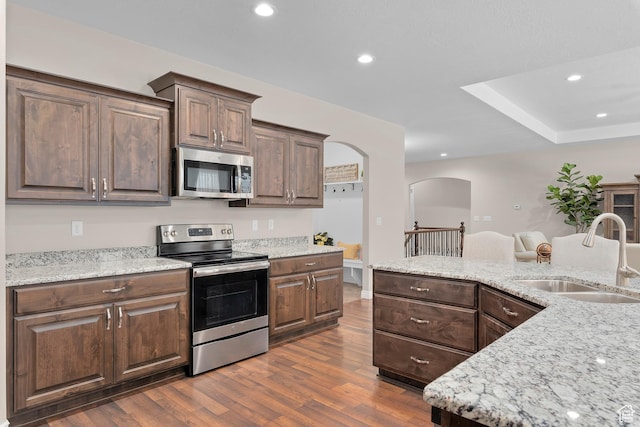 649 E 5650 S, Washington Terrace, UT 84405 - kitchen with appliances with stainless steel finishes, dark wood-type flooring, recessed lighting, arched walkways, and light stone counters