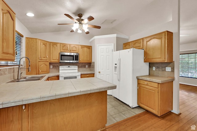 4188 S 2725 W, Roy, UT 84067 - kitchen featuring white appliances, vaulted ceiling, a ceiling fan, backsplash, and a peninsula