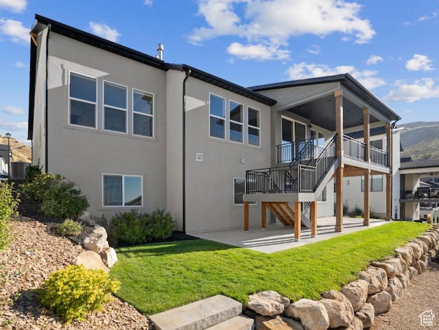 5885 N Canyon Rim Rd Unit 624, Lehi, UT 84043 - rear view of house featuring stucco siding, a patio, stairs, and a lawn