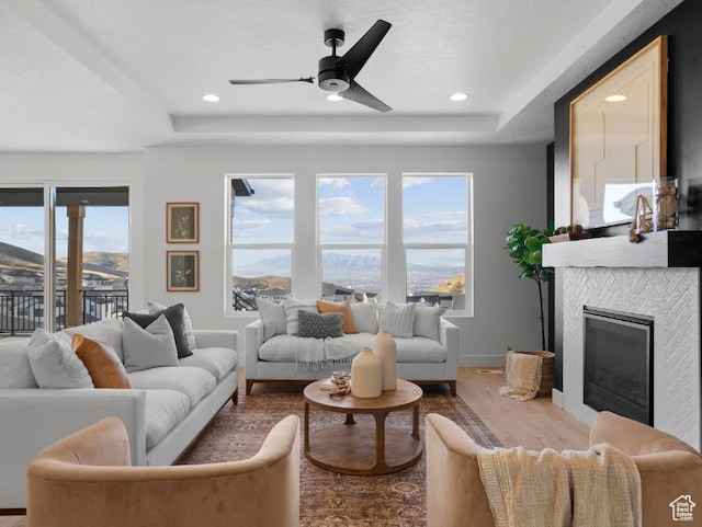 5885 N Canyon Rim Rd Unit 624, Lehi, UT 84043 - living area featuring a raised ceiling, wood finished floors, a tile fireplace, ceiling fan, and recessed lighting