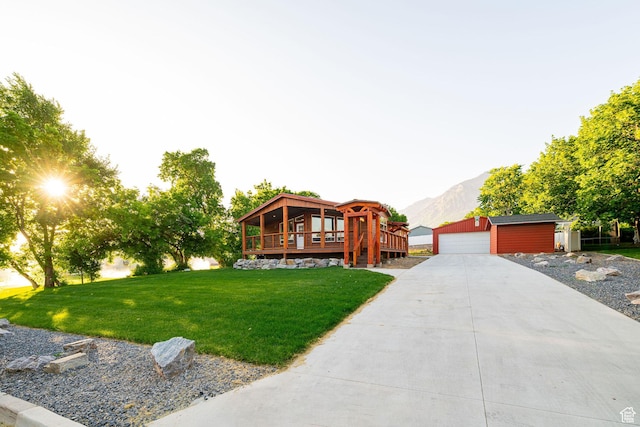432 E 2700 N, North Ogden, UT 84414 - view of front facade with an outdoor structure, a front lawn, a deck with mountain view, and a garage
