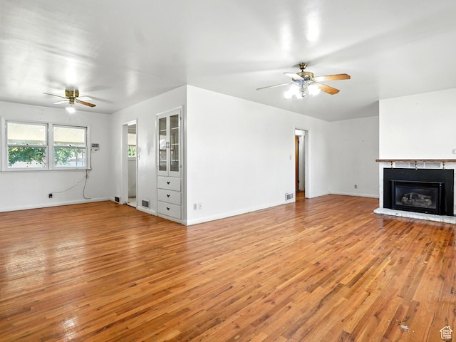 1951 W 4900 S, Roy, UT 84067 - unfurnished living room featuring ceiling fan, light wood-style floors, and a glass covered fireplace