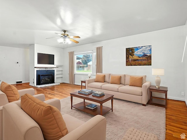 1951 W 4900 S, Roy, UT 84067 - living room with light wood finished floors, a ceiling fan, and a glass covered fireplace