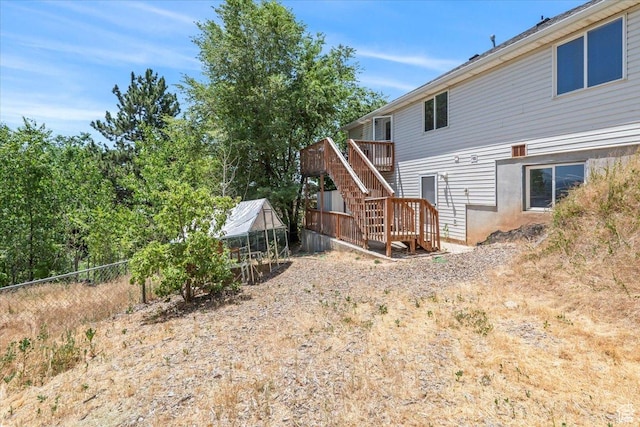 3186 N 1175 E, Layton, UT 84040 - back of house with stairway, a deck, a greenhouse, and an outbuilding