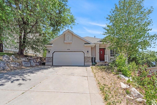 3186 N 1175 E, Layton, UT 84040 - view of front of home with stucco siding, an attached garage, stone siding, and concrete driveway