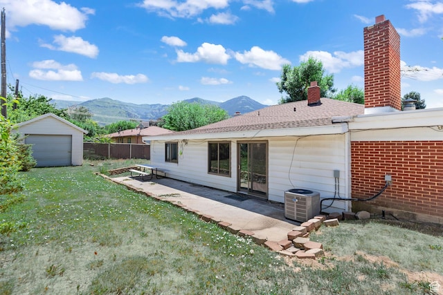 680 E 2800 N, North Ogden, UT 84414 - back of house featuring a mountain view, a chimney, a patio, an outdoor structure, and a garage