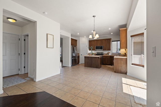 3991 W Hollandia Ln, West Jordan, UT 84084 - kitchen featuring appliances with stainless steel finishes, a center island, a chandelier, light countertops, and light tile patterned flooring