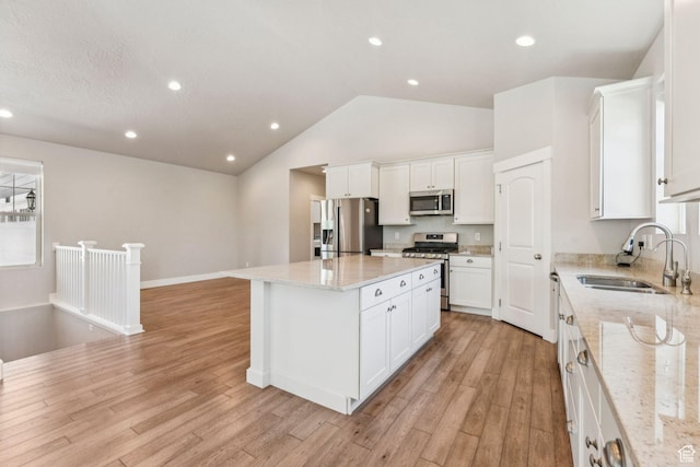 11103 S Kiwano Way W, South Jordan, UT 84009 - kitchen with appliances with stainless steel finishes, a center island, light wood-type flooring, white cabinetry, and vaulted ceiling
