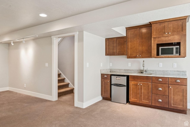 11103 S Kiwano Way W, South Jordan, UT 84009 - kitchen with stainless steel appliances, light carpet, brown cabinets, and light stone countertops