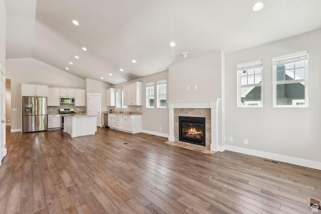 11103 S Kiwano Way W, South Jordan, UT 84009 - unfurnished living room with a fireplace, wood finished floors, lofted ceiling, and recessed lighting