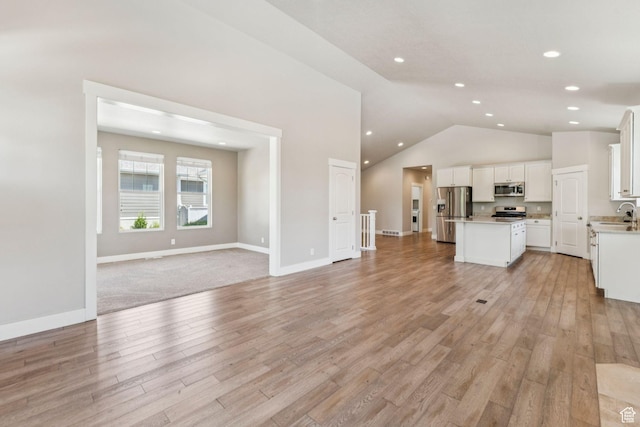11103 S Kiwano Way W, South Jordan, UT 84009 - unfurnished living room with light wood-type flooring, lofted ceiling, and recessed lighting