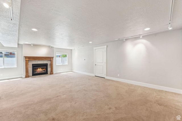 11103 S Kiwano Way W, South Jordan, UT 84009 - unfurnished living room featuring a textured ceiling, carpet, a tiled fireplace, recessed lighting, and track lighting