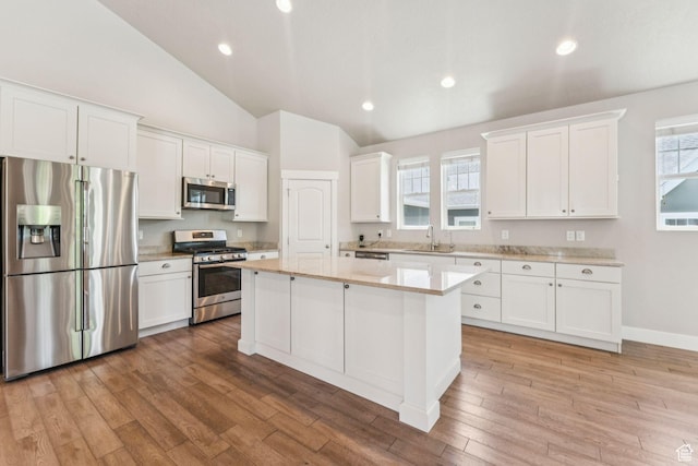11103 S Kiwano Way W, South Jordan, UT 84009 - kitchen featuring appliances with stainless steel finishes, lofted ceiling, white cabinetry, a kitchen island, and light countertops