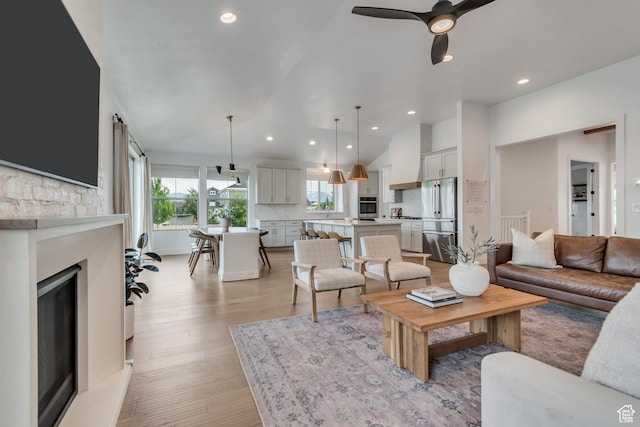 387 S 300 E, Midway, UT 84049 - living room with plenty of natural light, recessed lighting, light wood finished floors, a fireplace with raised hearth, and vaulted ceiling