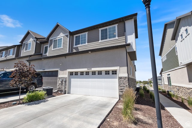 5680 W Pelican Ridge Ln, Salt Lake City, UT 84118 - townhome / multi-family property with stone siding, a garage, driveway, and stucco siding