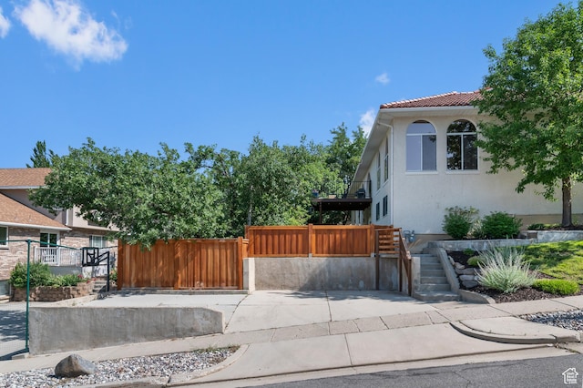 7968 S Titian St E, Cottonwood Heights, UT 84121 - view of side of property with a fenced front yard, a gate, stucco siding, and a tile roof