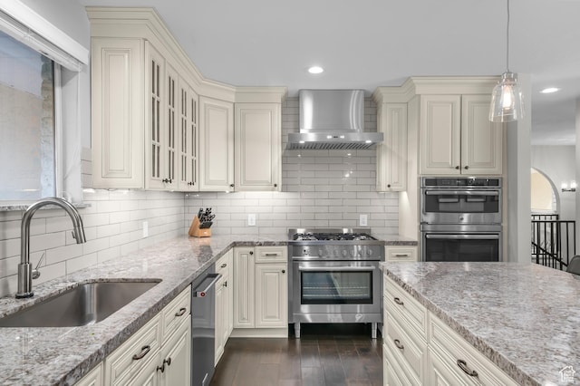 7968 S Titian St E, Cottonwood Heights, UT 84121 - kitchen featuring appliances with stainless steel finishes, wall chimney range hood, light stone countertops, cream cabinets, and recessed lighting