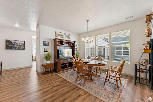 155 N 3830 W, West Point, UT 84015 - dining space featuring wood finished floors, a chandelier, and a textured ceiling