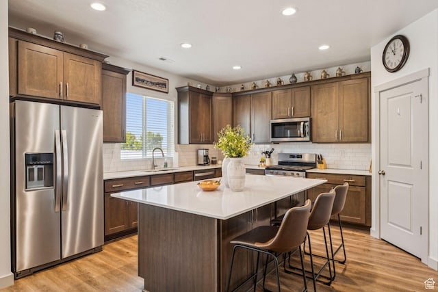 155 N 3830 W, West Point, UT 84015 - kitchen with stainless steel appliances, a kitchen island, light wood-style flooring, light countertops, and recessed lighting