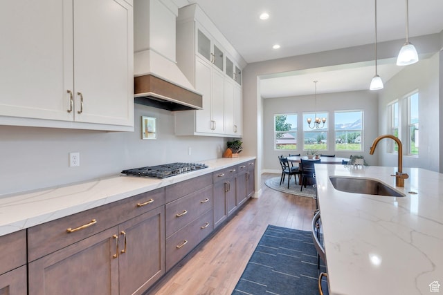 586 S Appenzell Ln W Unit 16, Midway, UT 84049 - kitchen featuring custom range hood, white cabinets, stainless steel gas cooktop, a chandelier, and recessed lighting