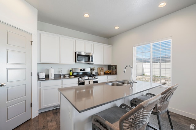 528 S Musk Ave W, Grantsville, UT 84029 - kitchen featuring appliances with stainless steel finishes, a kitchen breakfast bar, an island with sink, recessed lighting, and white cabinets