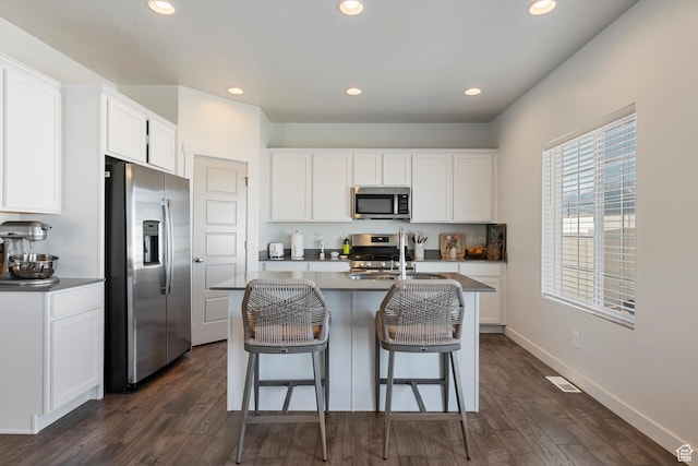528 S Musk Ave W, Grantsville, UT 84029 - kitchen featuring stainless steel appliances, dark wood-style floors, recessed lighting, white cabinets, and a kitchen bar