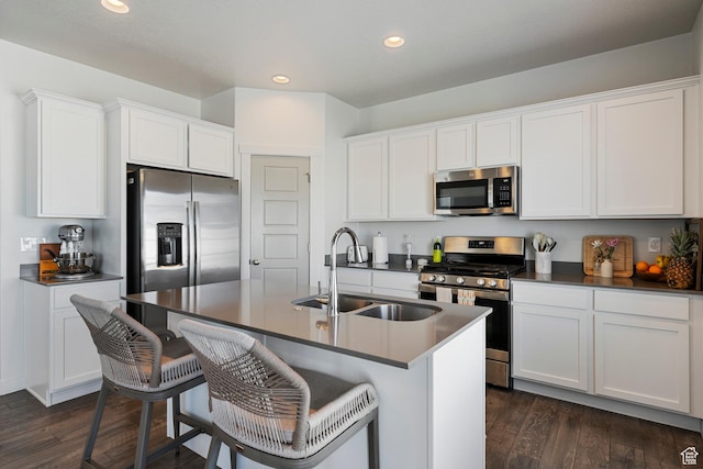 528 S Musk Ave W, Grantsville, UT 84029 - kitchen with appliances with stainless steel finishes, dark countertops, recessed lighting, a kitchen breakfast bar, and dark wood finished floors