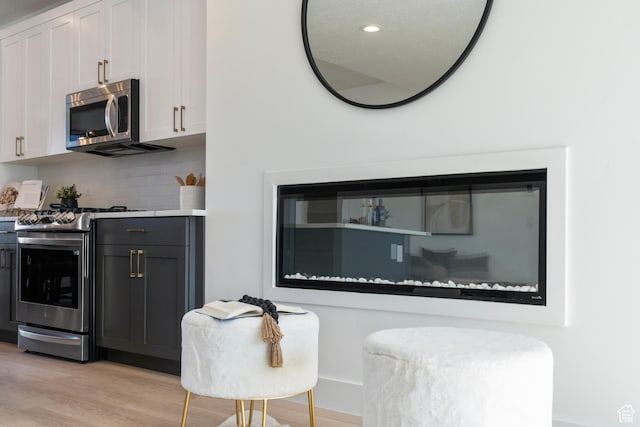 79 E Watson Dr, Saratoga Springs, UT 84045 - kitchen with appliances with stainless steel finishes, light wood finished floors, backsplash, recessed lighting, and white cabinetry
