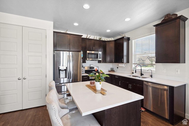 6228 N Boulter Peak Ln, Eagle Mountain, UT 84005 - kitchen featuring stainless steel appliances, a kitchen breakfast bar, dark brown cabinetry, light countertops, and dark wood finished floors