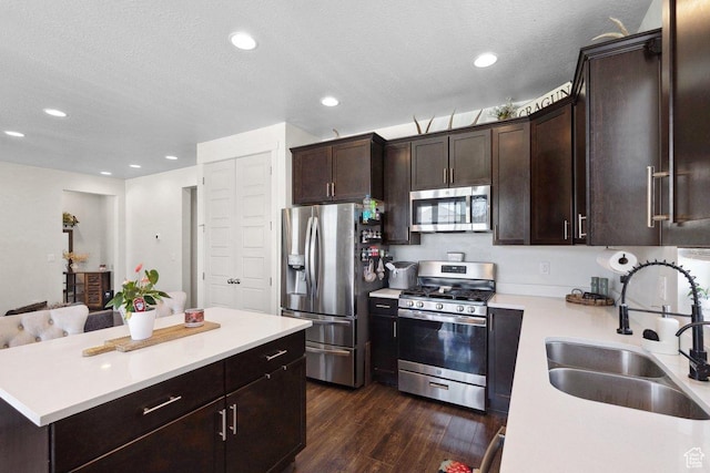 6228 N Boulter Peak Ln, Eagle Mountain, UT 84005 - kitchen with stainless steel appliances, dark wood-style flooring, light countertops, dark brown cabinets, and recessed lighting