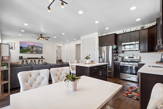 6228 N Boulter Peak Ln, Eagle Mountain, UT 84005 - kitchen with appliances with stainless steel finishes, a center island, dark brown cabinets, dark wood-style flooring, and light countertops