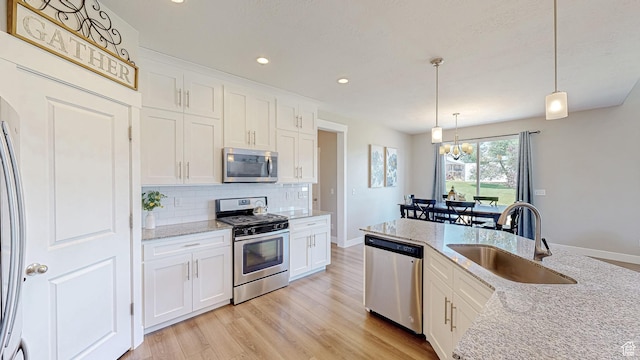 149 N 800 E, Salem, UT 84653 - kitchen featuring stainless steel appliances, a chandelier, backsplash, light wood-style flooring, and white cabinetry