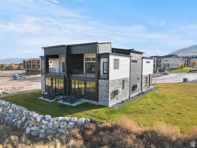 78 Watson Dr, Saratoga Springs, UT 84045 - rear view of house featuring a balcony, a yard, a mountain view, a residential view, and stone siding