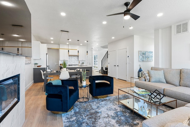 78 Watson Dr, Saratoga Springs, UT 84045 - living area with a ceiling fan, light wood-style flooring, a fireplace, stairs, and recessed lighting