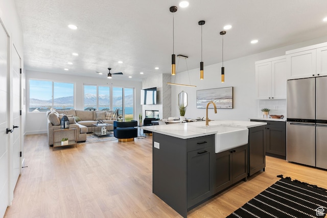 78 Watson Dr, Saratoga Springs, UT 84045 - kitchen with freestanding refrigerator, light wood-style floors, recessed lighting, open floor plan, and light stone countertops
