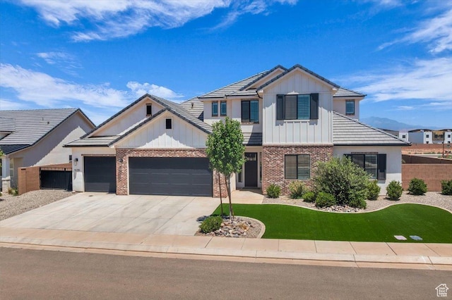 529 E 4290 S, Washington, UT 84780 - modern inspired farmhouse featuring board and batten siding, brick siding, an attached garage, concrete driveway, and a front lawn