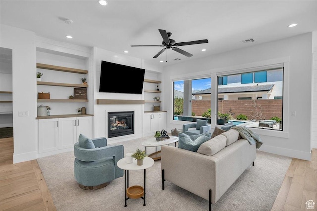 529 E 4290 S, Washington, UT 84780 - living area with light wood finished floors, recessed lighting, a glass covered fireplace, a ceiling fan, and built in shelves